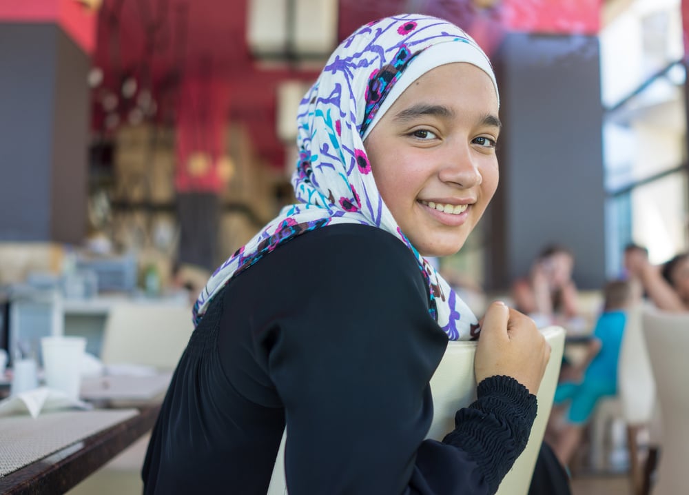 Happy Muslim family in restaurant