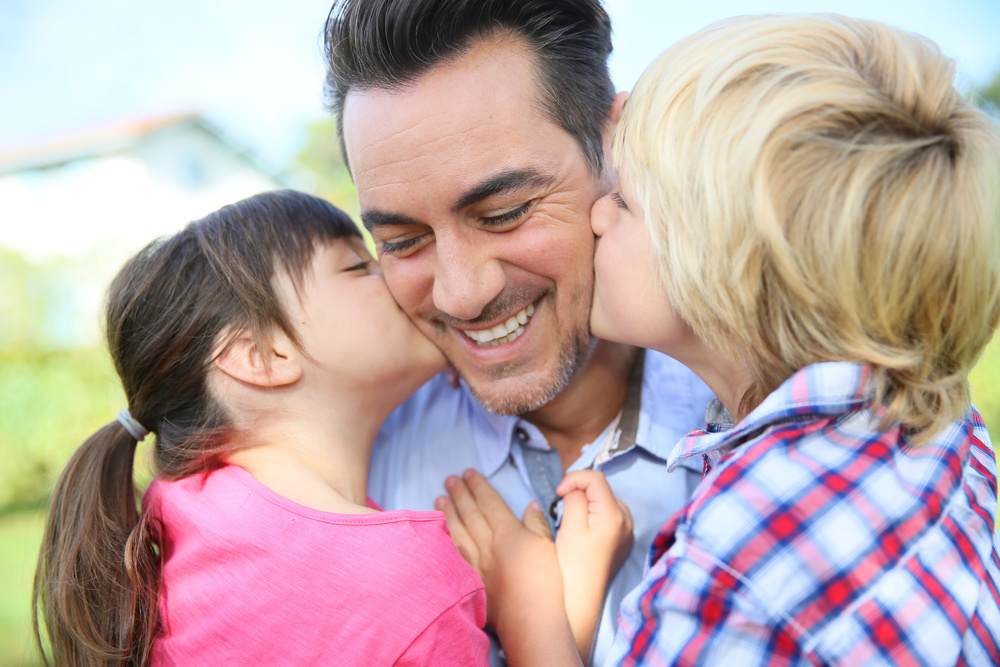 Portrait of kids giving a kiss to their daddy